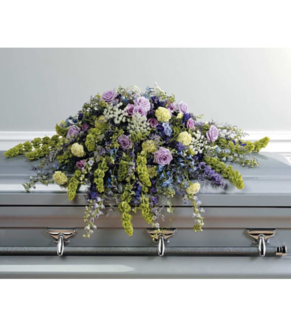 Lavender and white floral spray on a gray casket