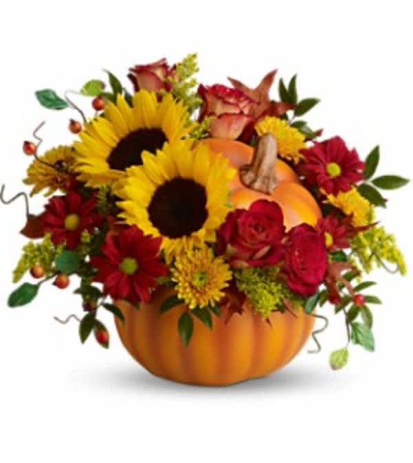Pumpkin-shaped arrangement with sunflowers and red flowers