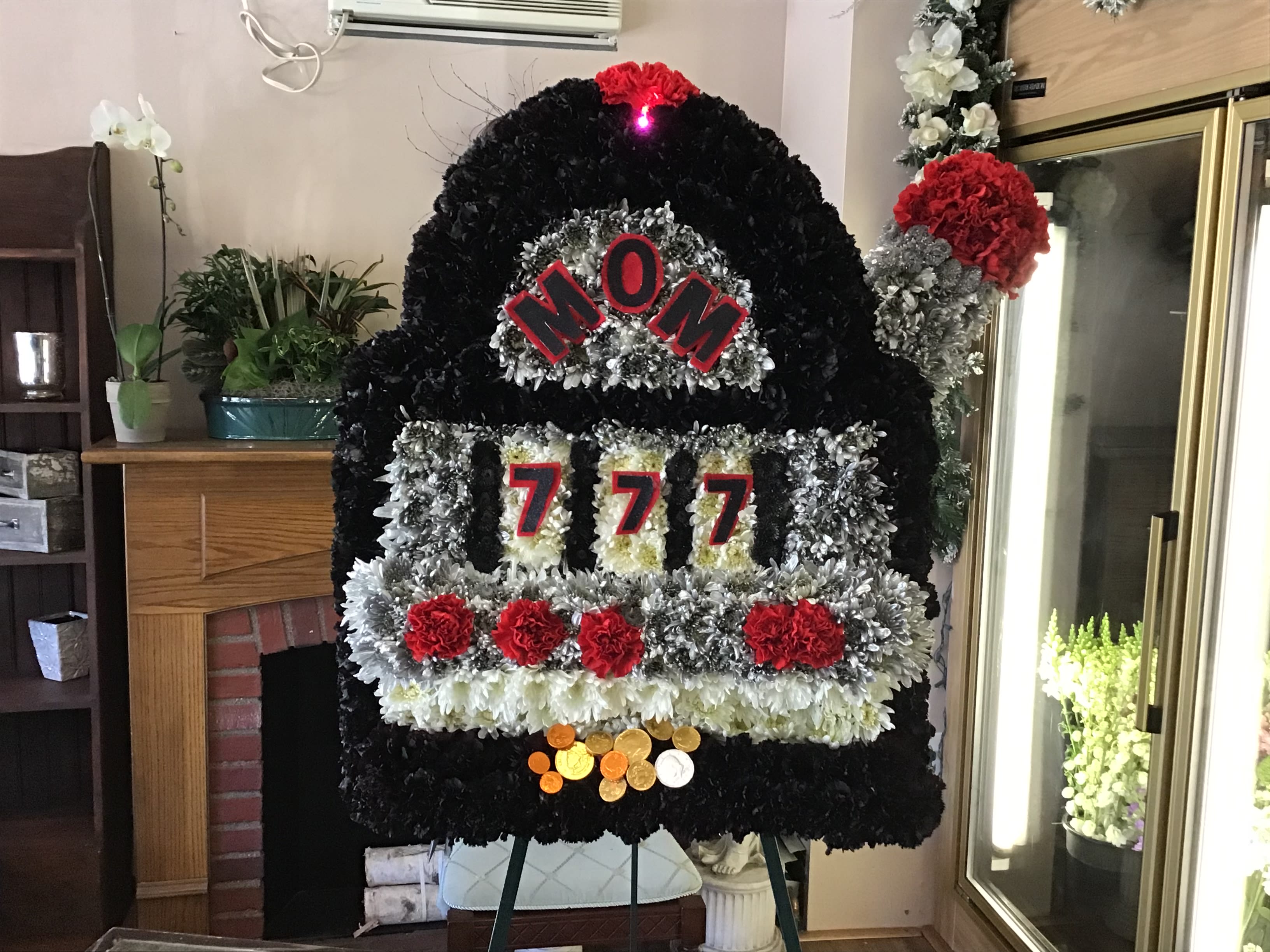 Large floral tribute shaped like a slot machine with red and black flowers