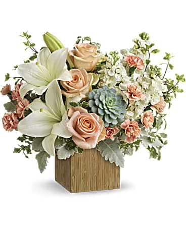 Arrangement of lilies, roses, carnations, and succulents in a wooden cube vase