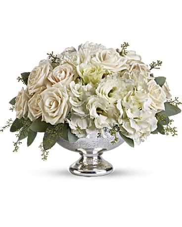 White rose arrangement in a silver pedestal bowl