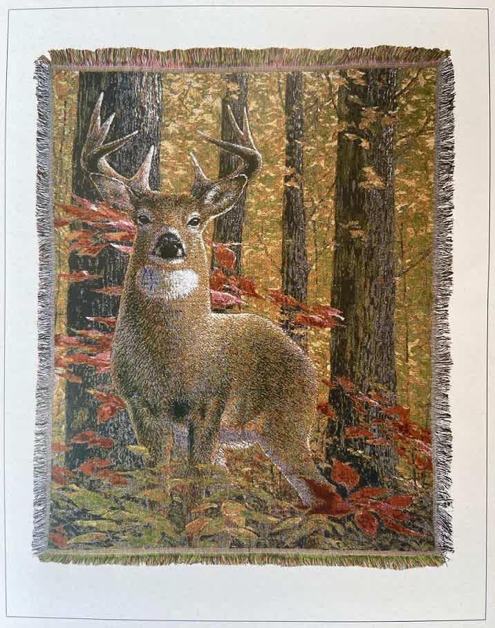 Fringed wall hanging with a deer in an autumn forest scene