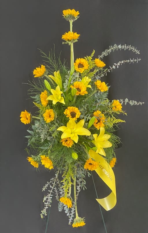 Tall yellow floral spray with lilies and daisy-like blooms on a stand
