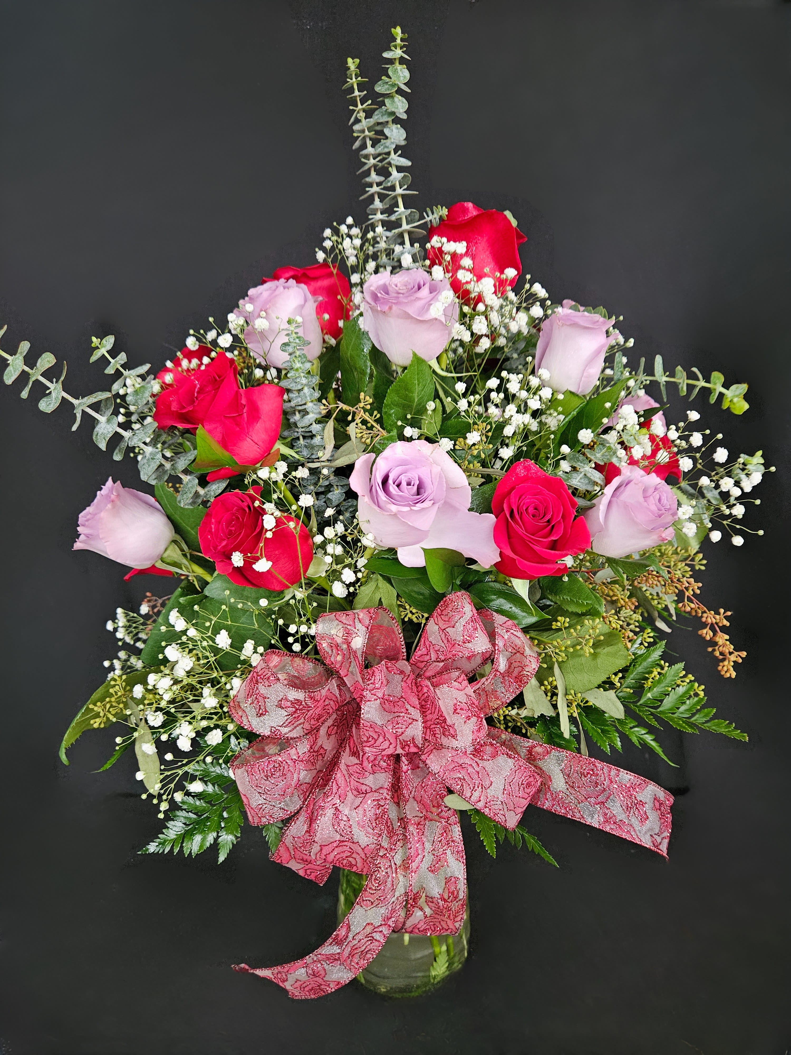 Sweet Devotion - 2 Dozen Red &amp; Lavender Roses - Express your love for the number one in your life with this beautiful arrangement of two dozen red and lavender roses artfully arranged with baby's breath and decorative greens.