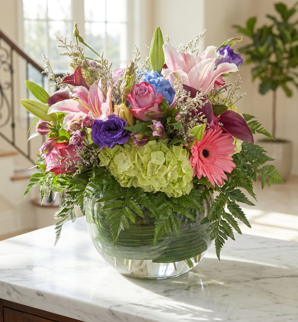 Mixed bouquet with lilies, roses, hydrangea, and a gerbera daisy in a glass vase