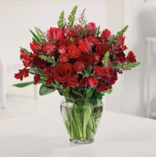 Red mixed flower bouquet in a clear glass vase