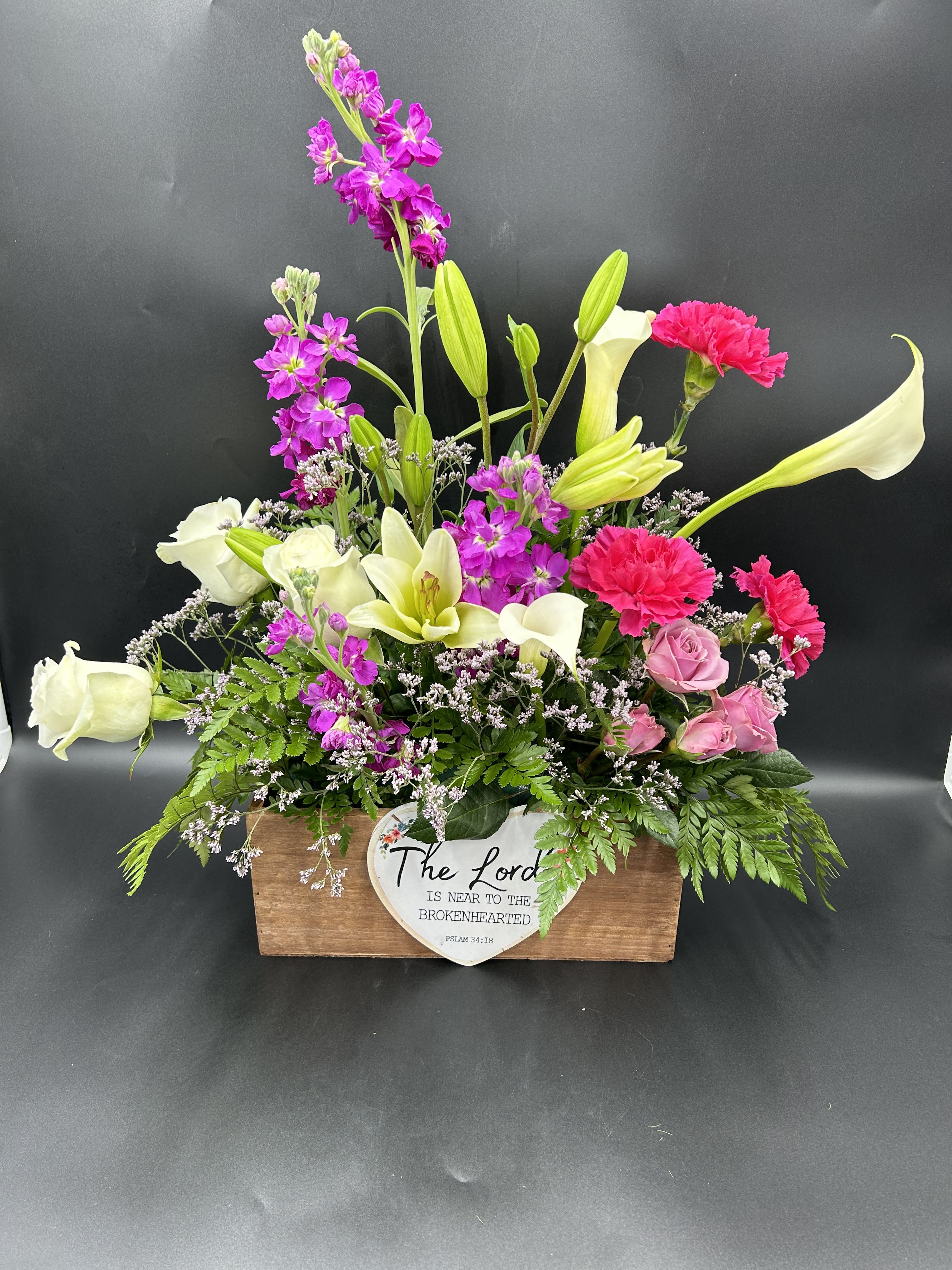 Mixed bouquet in a wooden box with white calla lilies, pink roses, and magenta blooms