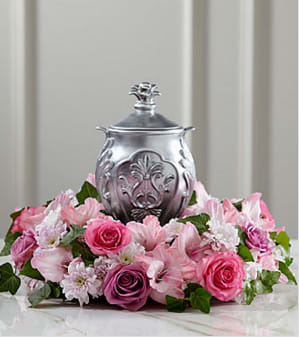 Pink and white floral arrangement around a silver urn