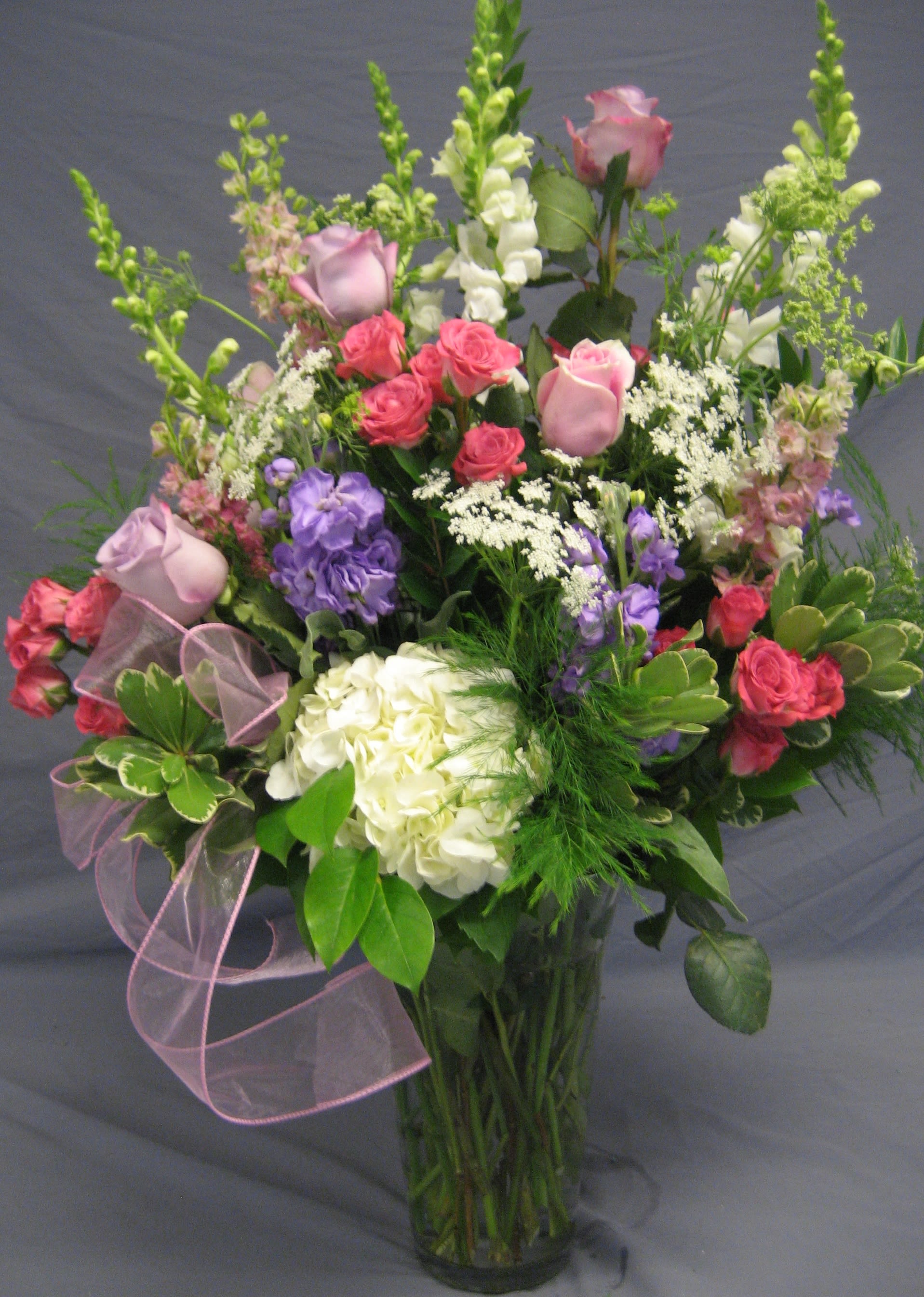Always a Lady V09 - This large vase arrangement can be used as tribute piece or a everyday floral gift of pastel flowers. Upgrading to Deluxe or Premium will add more flowers to your piece