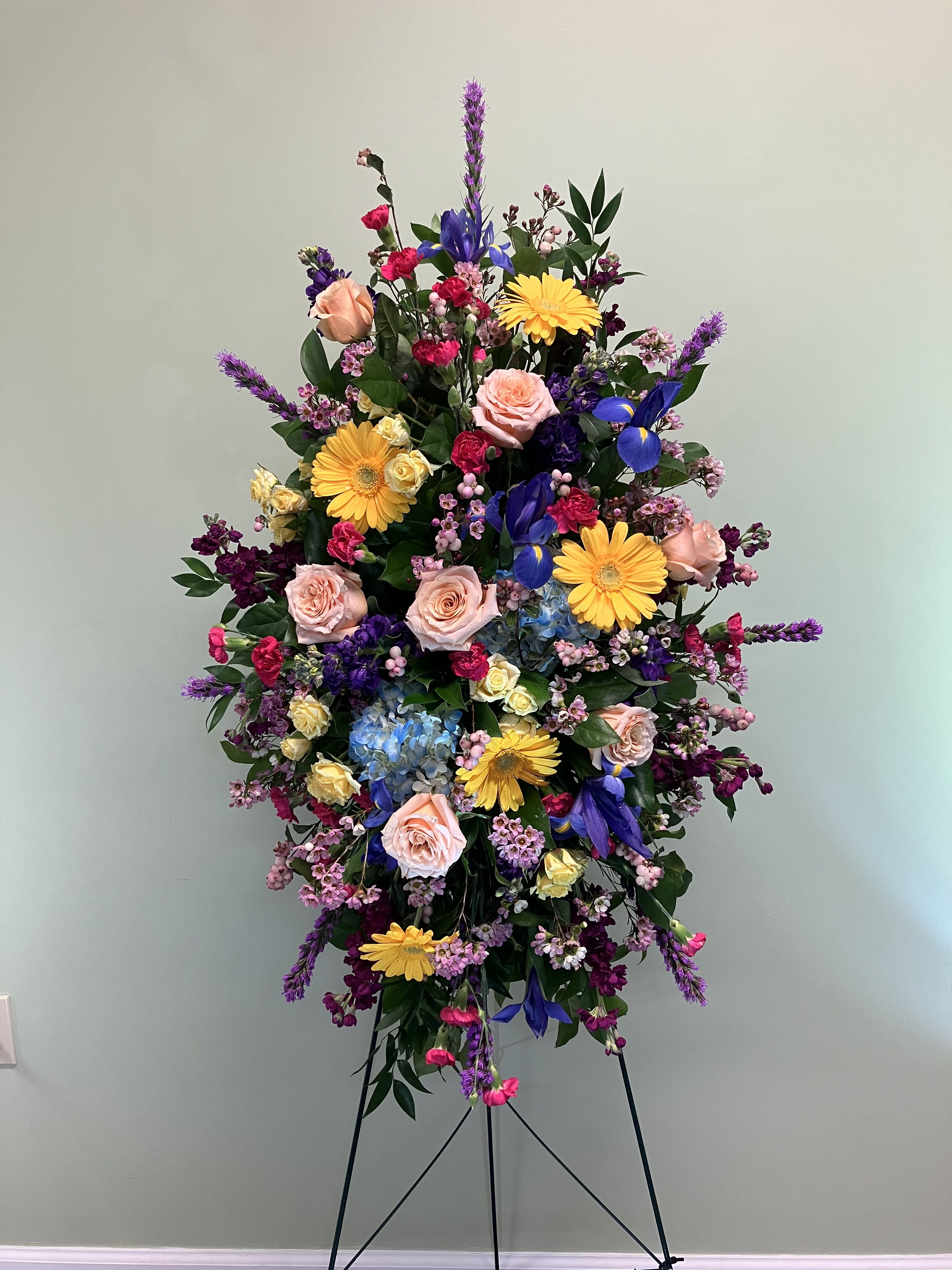 Colorful Garden Standing Spray E20  - This easel spray tribute is designed in a bright mix of fresh flowers. Upgrading to Deluxe or Premium will add more flowers to your design. **Ribbon Script is an additional $10