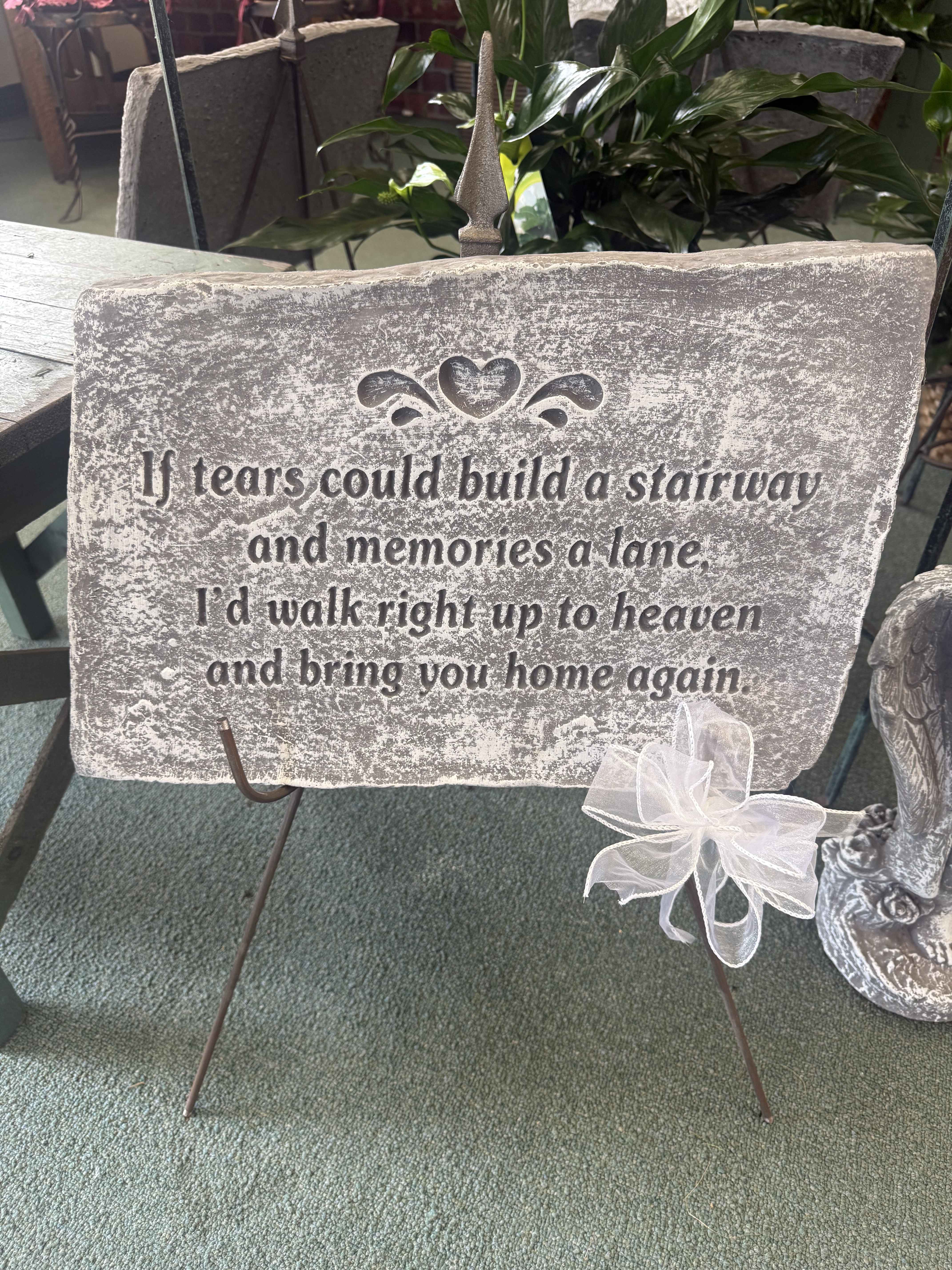 Memorial stone sign on a metal stand with a white ribbon bow