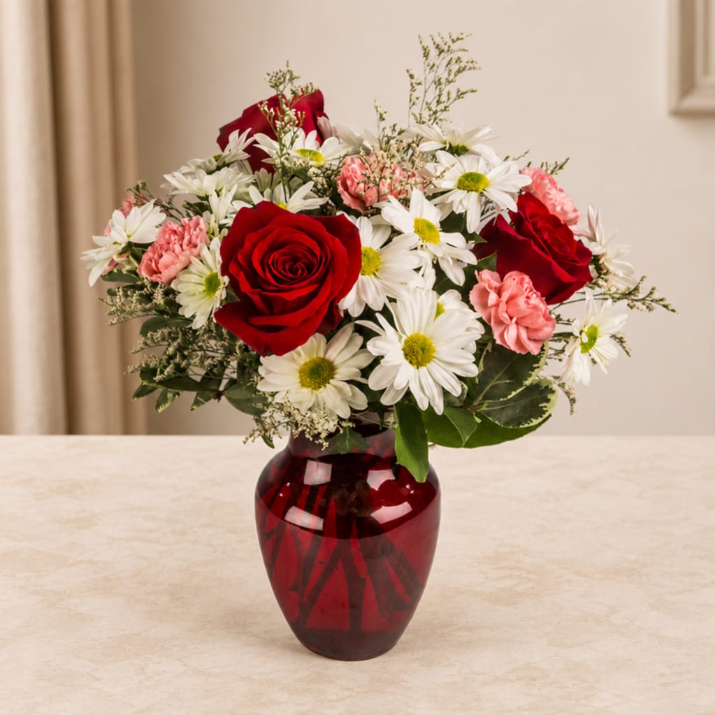 Red roses and white daisies in a red glass vase