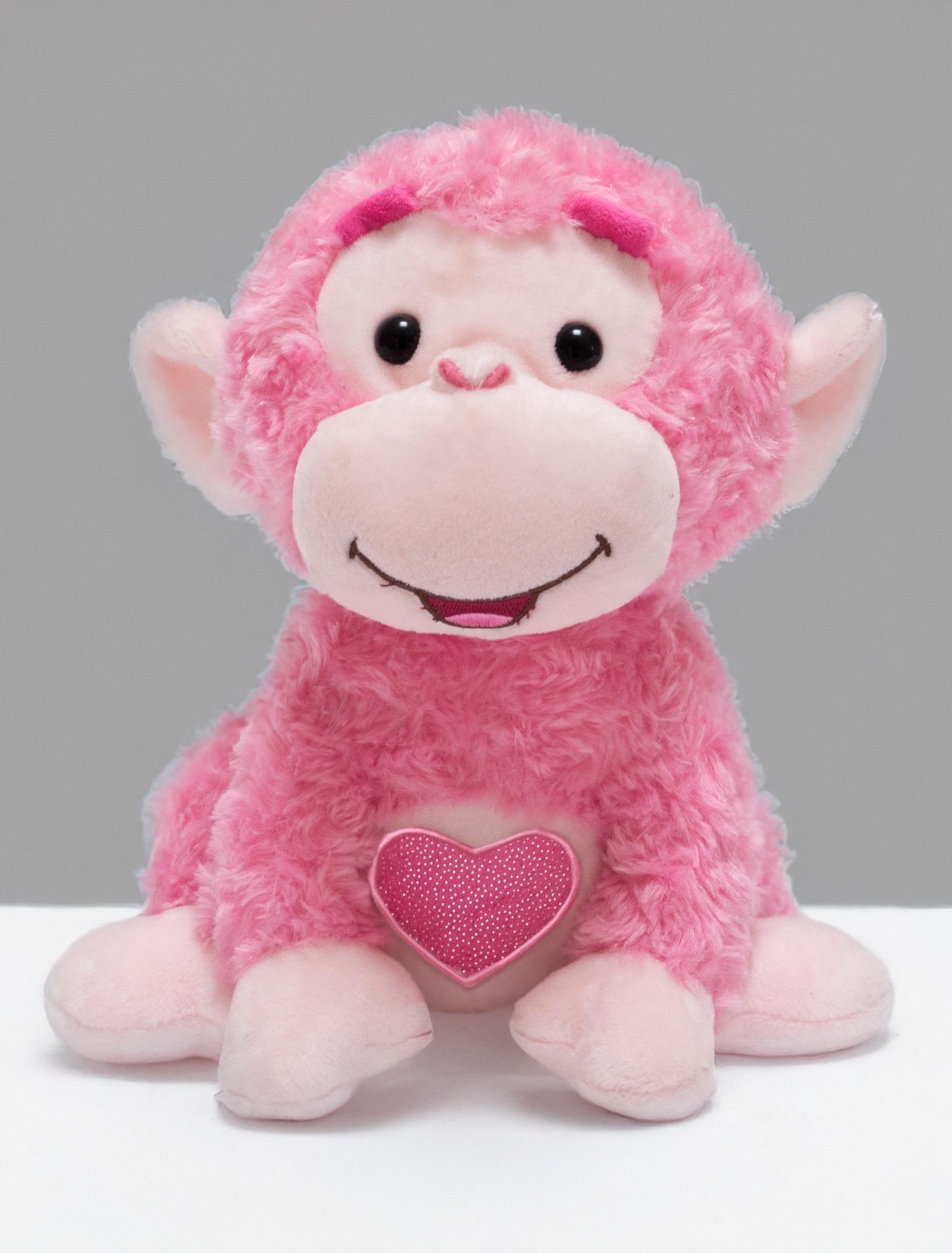 Pink plush monkey holding a heart
