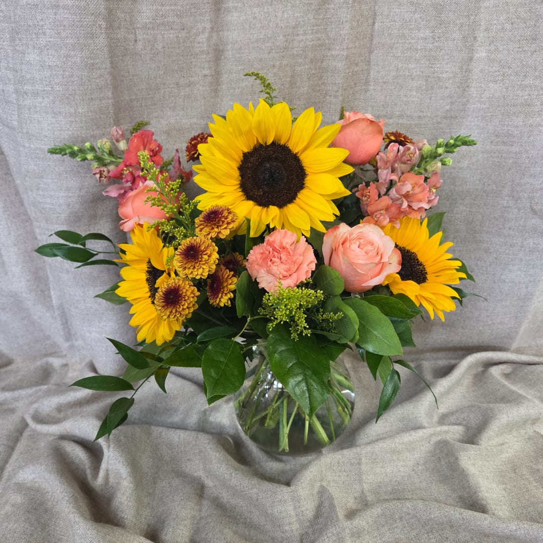 Sunflower and rose bouquet in a clear glass vase