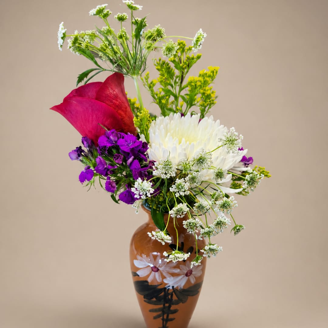 Mixed bouquet in a painted brown vase with white, purple, and red flowers