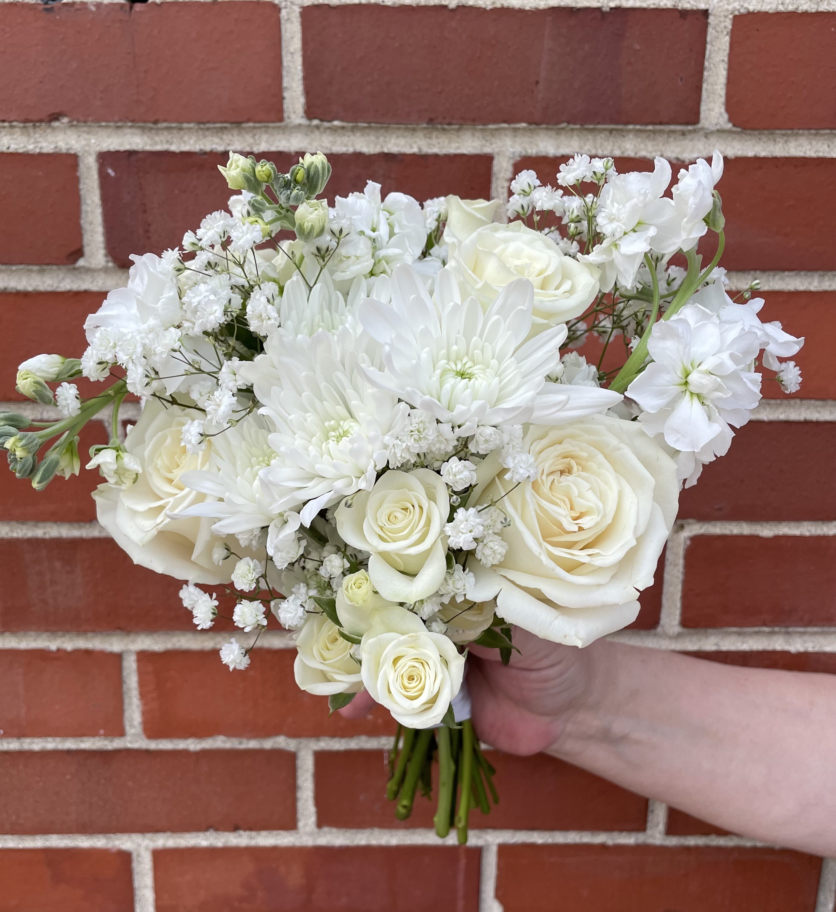 Posy Bouquet - A petite hand tied bouquet designed in your color palette of choice and finished with satin ribbon. A small vase is provided to keep the posy hydrated. Please note in the 'Special Instructions' box what colors you'd like to see in the posy along with any special ribbon color. If nothing is noted, we will design with white flowers, a bit of foliage and finish with ivory satin ribbon.   Please note that posey's are non-refundable after being made. 