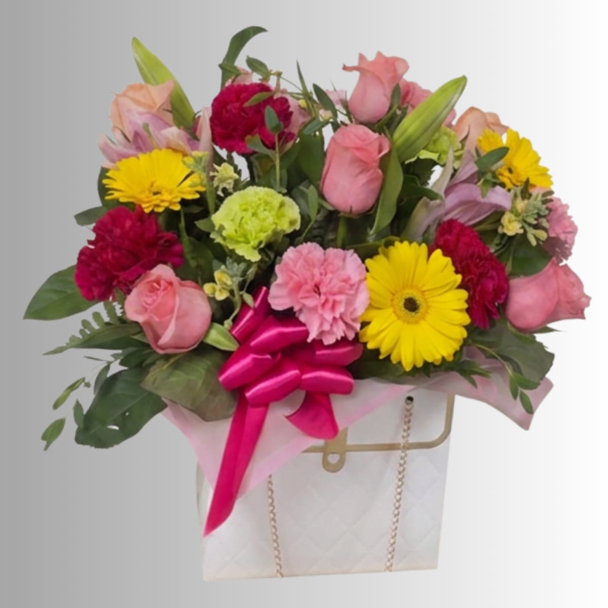 Mixed bouquet of pink roses, yellow daisies, and carnations in a gift bag