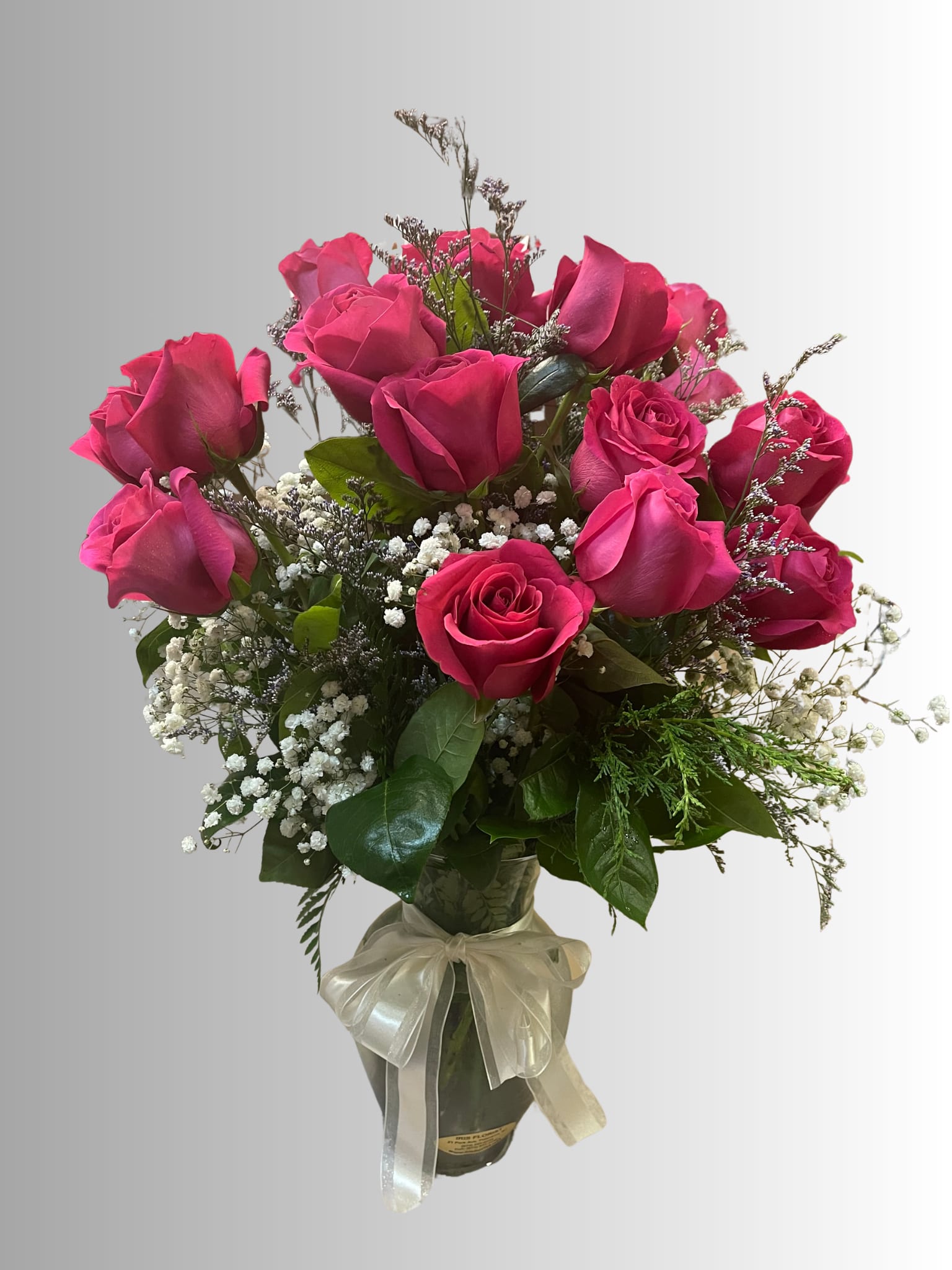 Bouquet of pink roses in a glass vase with a ribbon bow