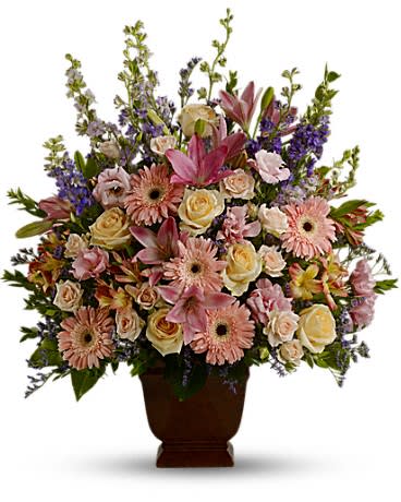 Mixed pink and cream flowers in a brown urn vase