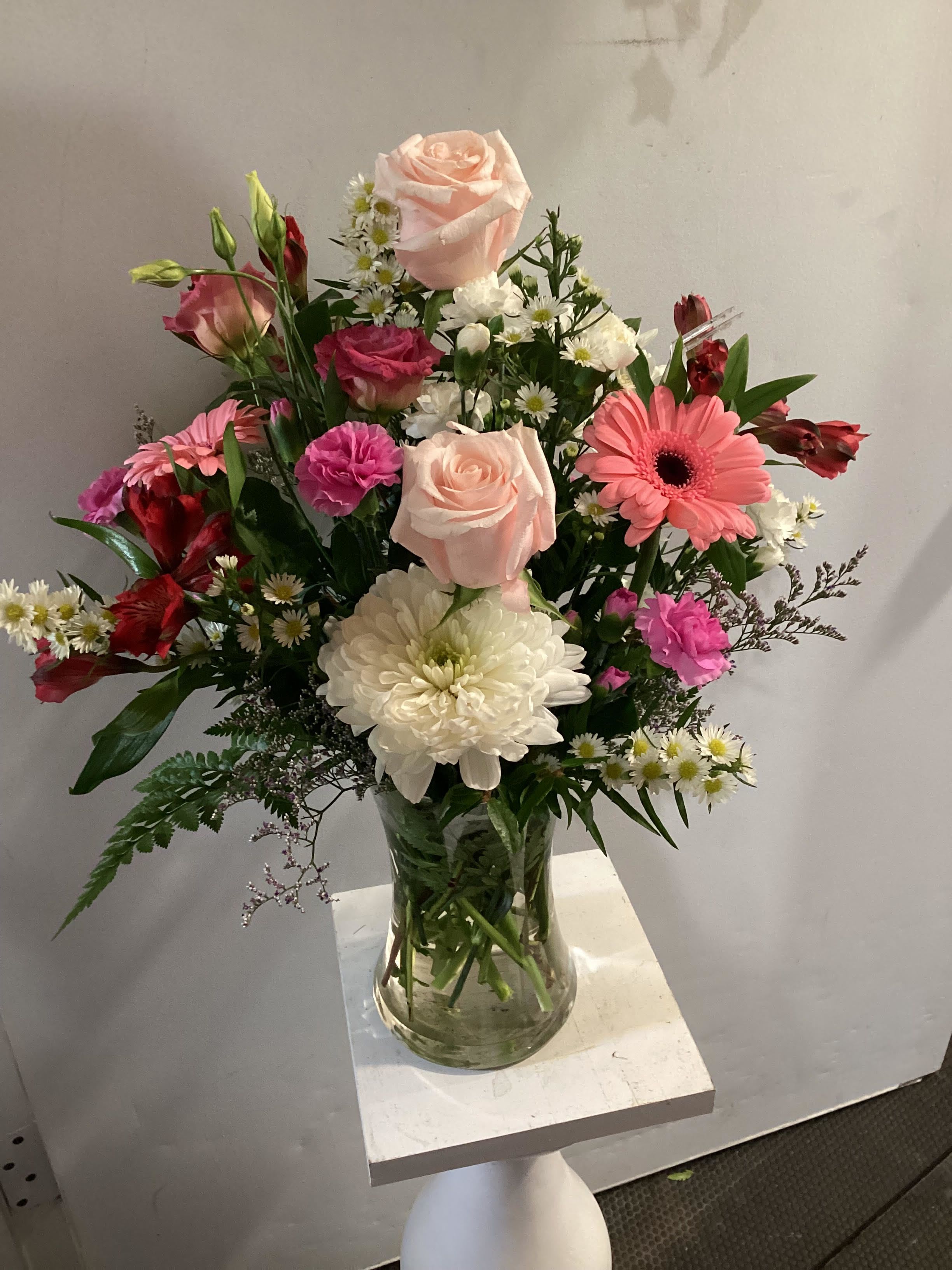 A MOTHER'S BEAUTY - A beautiful, spring-flower-filled arrangement for Mother's Day. Includes a variety of pink and white blooms