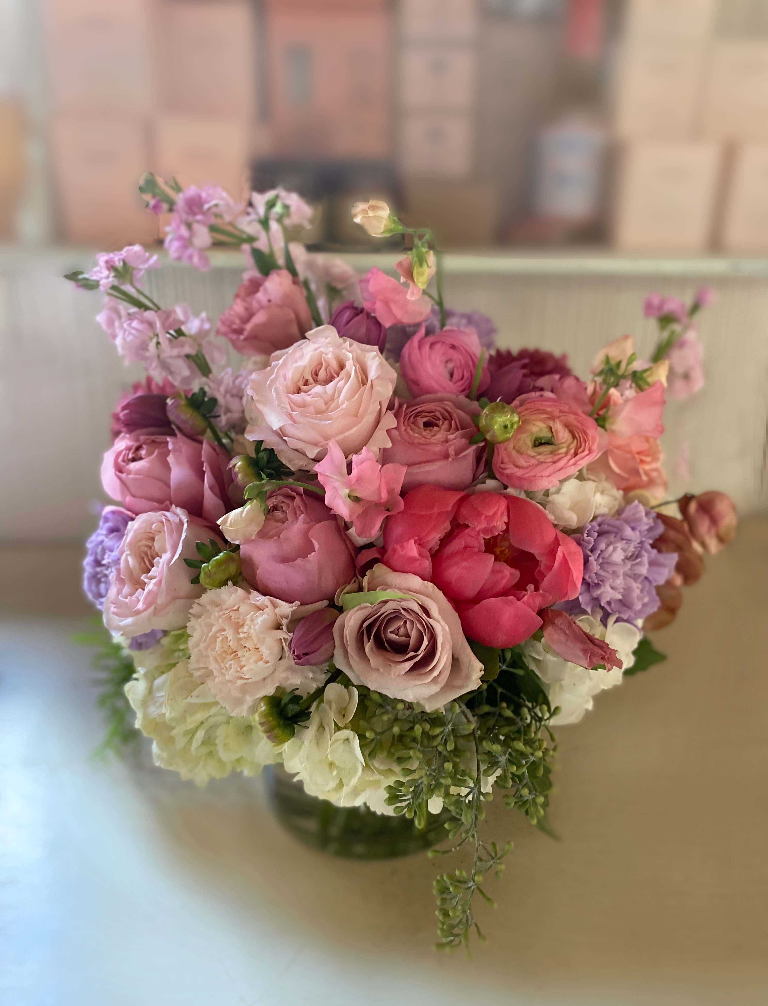 Pink and lavender bouquet of mixed flowers in a glass vase
