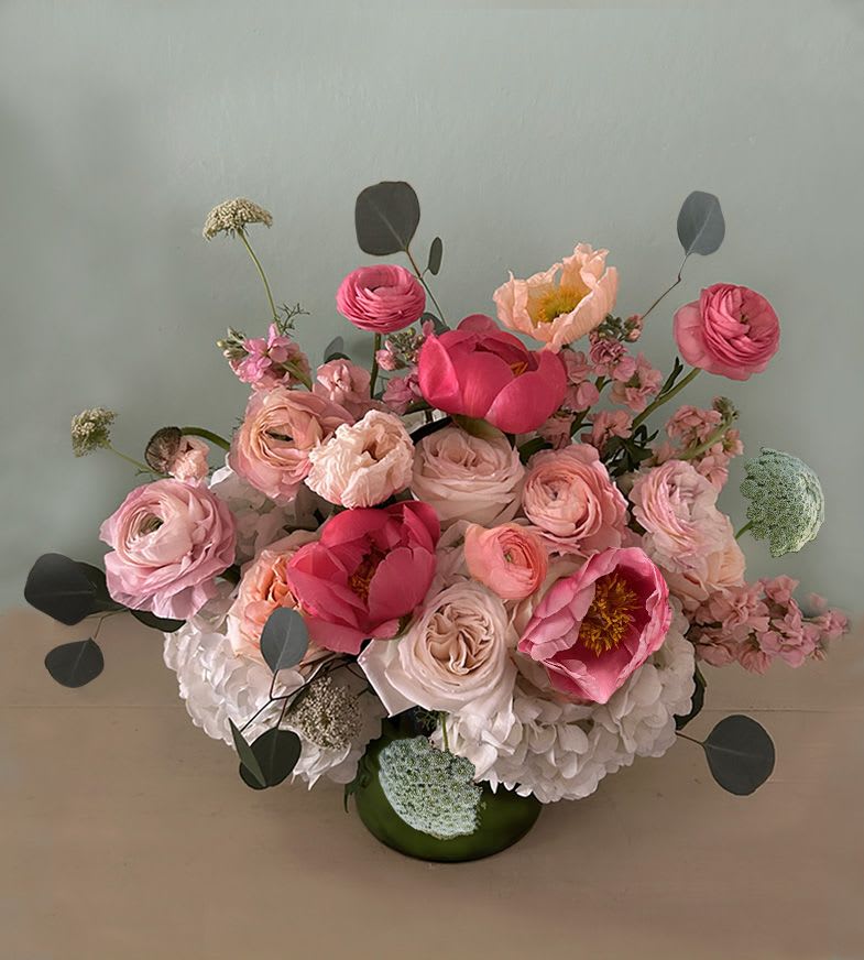 Pink and blush floral arrangement in a green vase