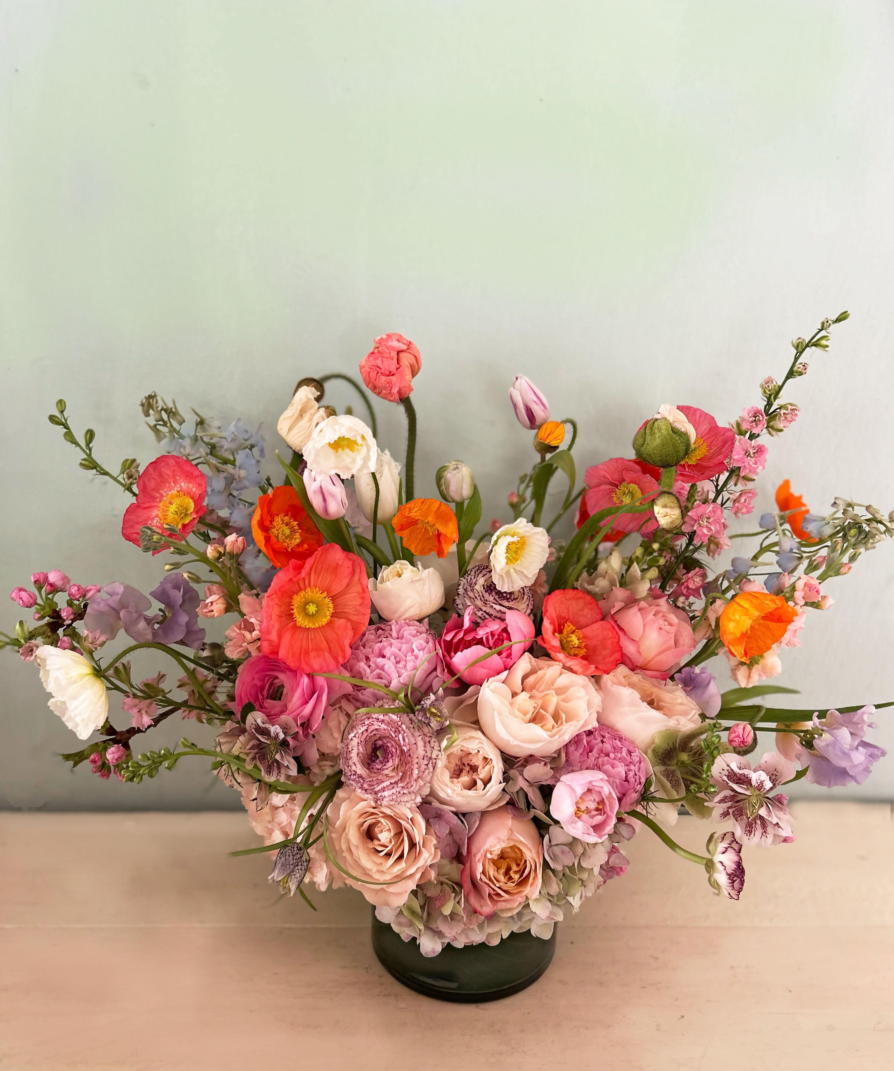 Jardín de primavera - This wild and natural x-large arrangement of the prettiest stems this spring will light up the hearts and homes of any recipient who is gifted this pretty, fresh and ethereal arrangement. Placed in a 7 by 7 clear vase and packed with beauty. Peonies, ranunculus, poppies, tulips and other gorgeous stems.