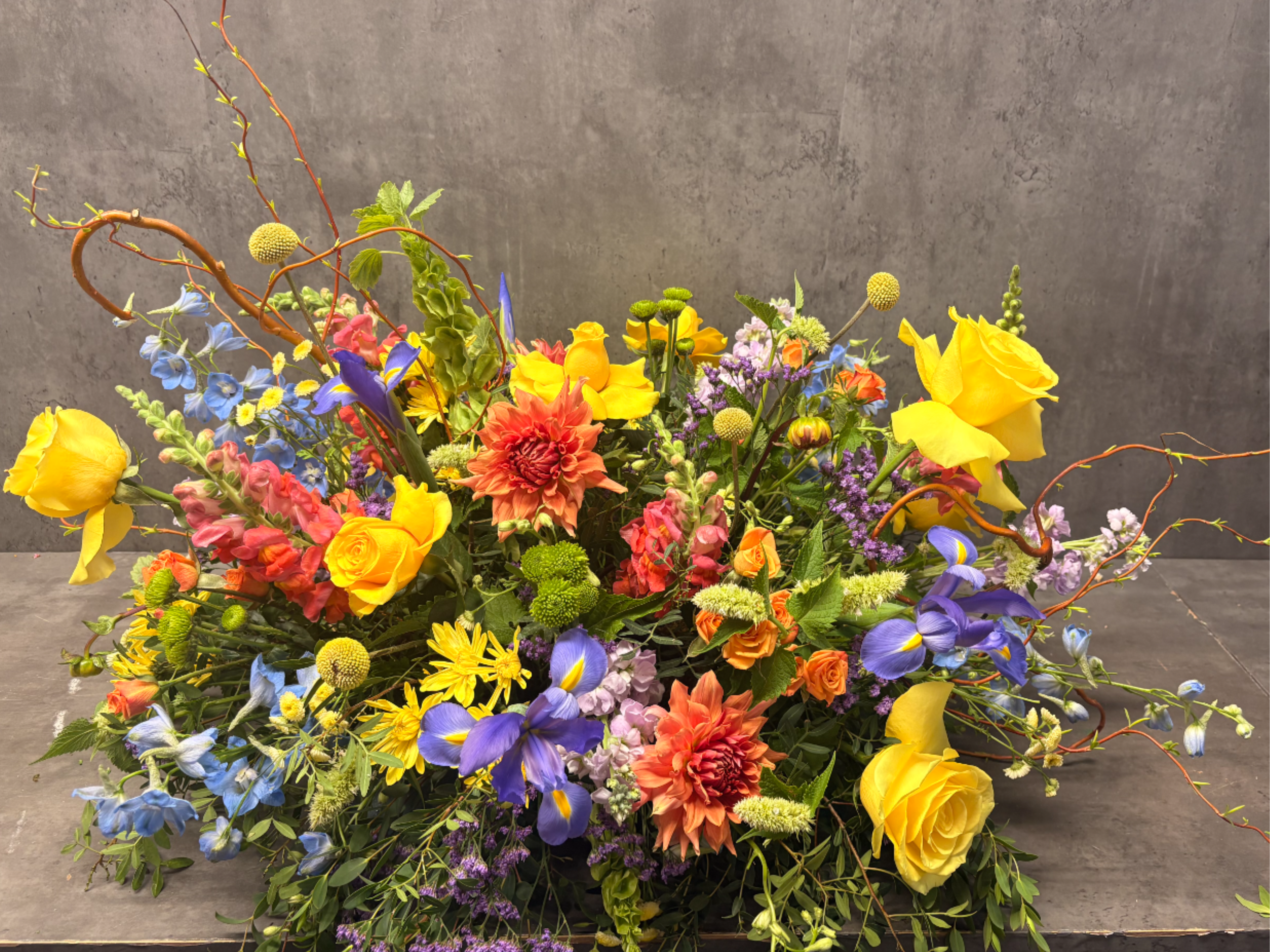Colorful Casket Spray - Honor a loved one with a half or full casket spray. Created with a variety of bright flowers. ***COLOR PALETTE CAN BE SPECIFIED***  *Standard size is for half casket spray. **Premium is for full casket spray.