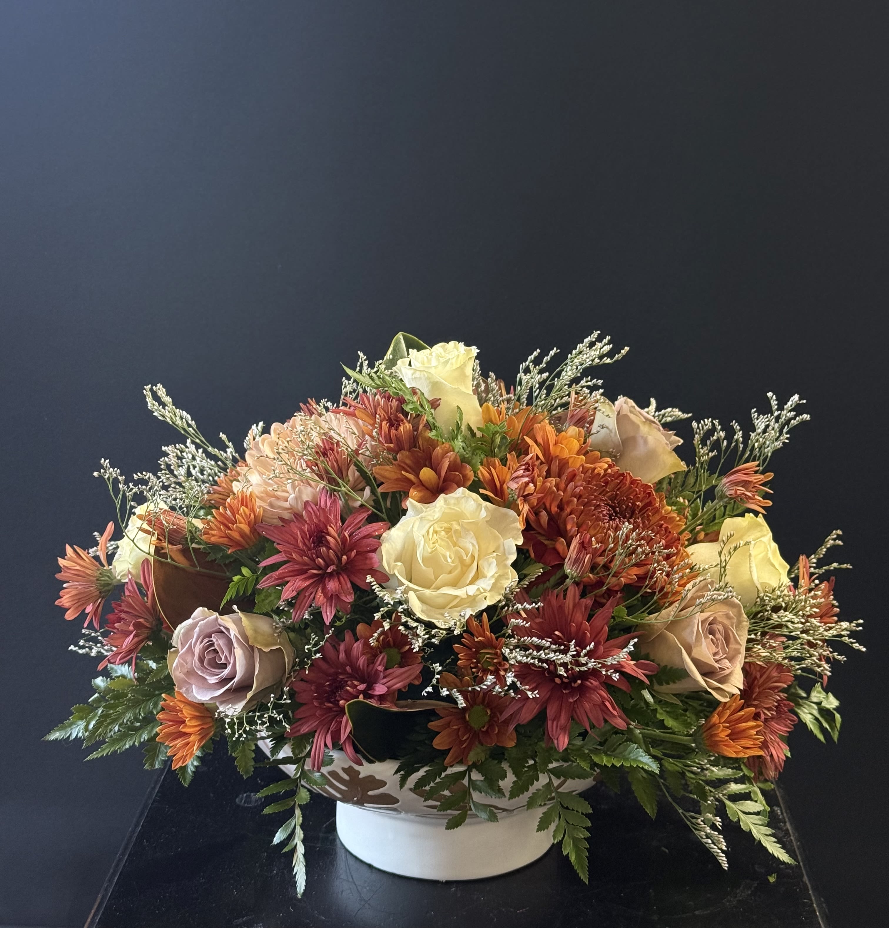 Amber Woods - An inviting arrangement filled with blooms in spiced tones, perfect for setting the mood during a cozy fall gathering.