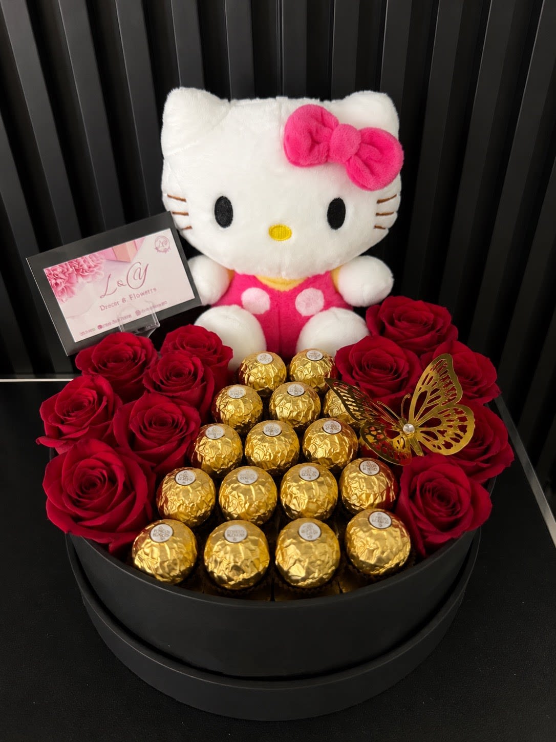 Hello kitty Luxury Rose - Sorprende a sea persona  especial con un regalo inolvidable. Este elegante arreglo combina un tierno peluche de hello kitty rosas rojas y chocolates ferreros diseñados en una sofisticado caja negra de lujo y decoradas con una mariposa dorado.