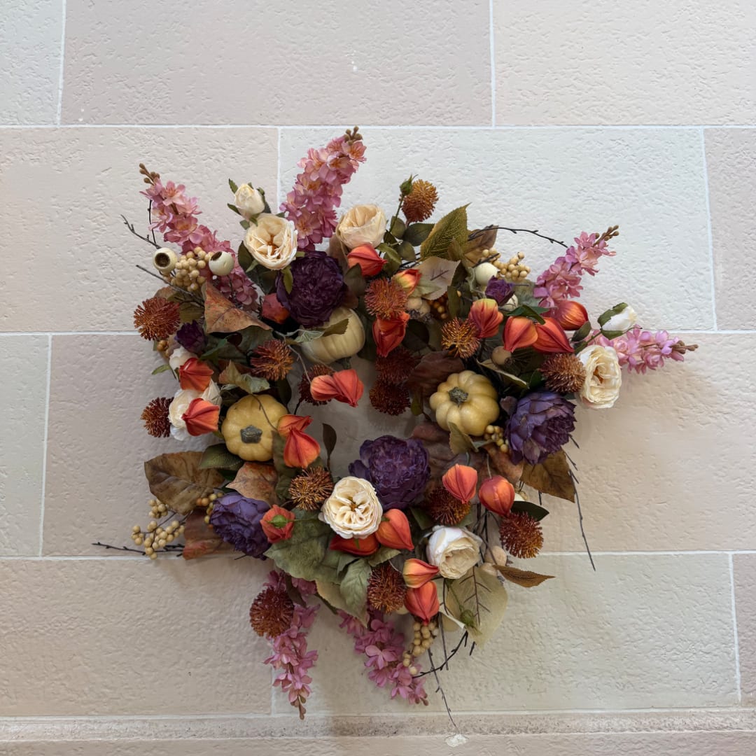 Autumn floral wreath with purple, orange, and cream blooms