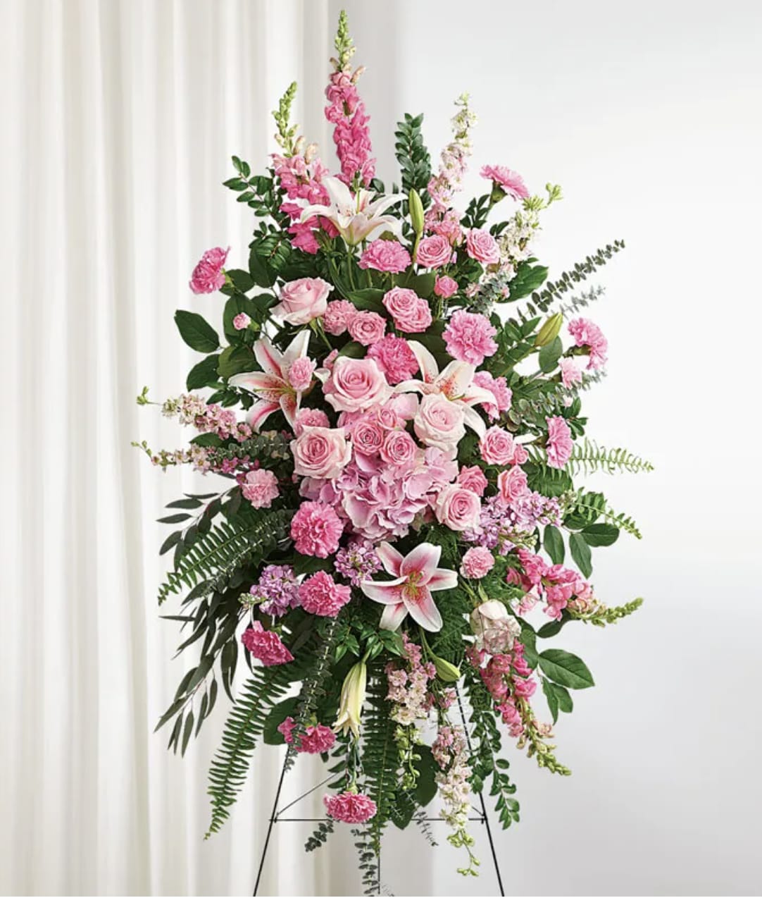 Tall pink floral standing spray on an easel with lilies and roses