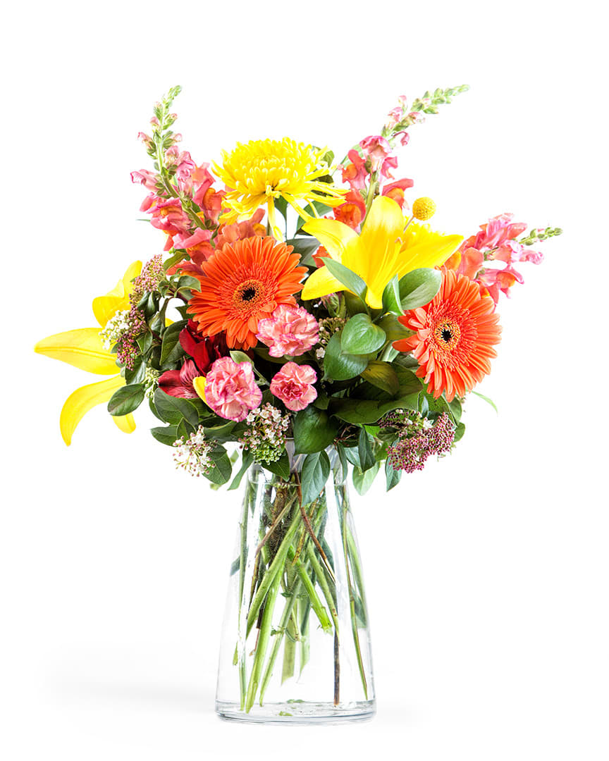 Bright mixed bouquet with yellow lilies and orange gerbera daisies in a glass vase