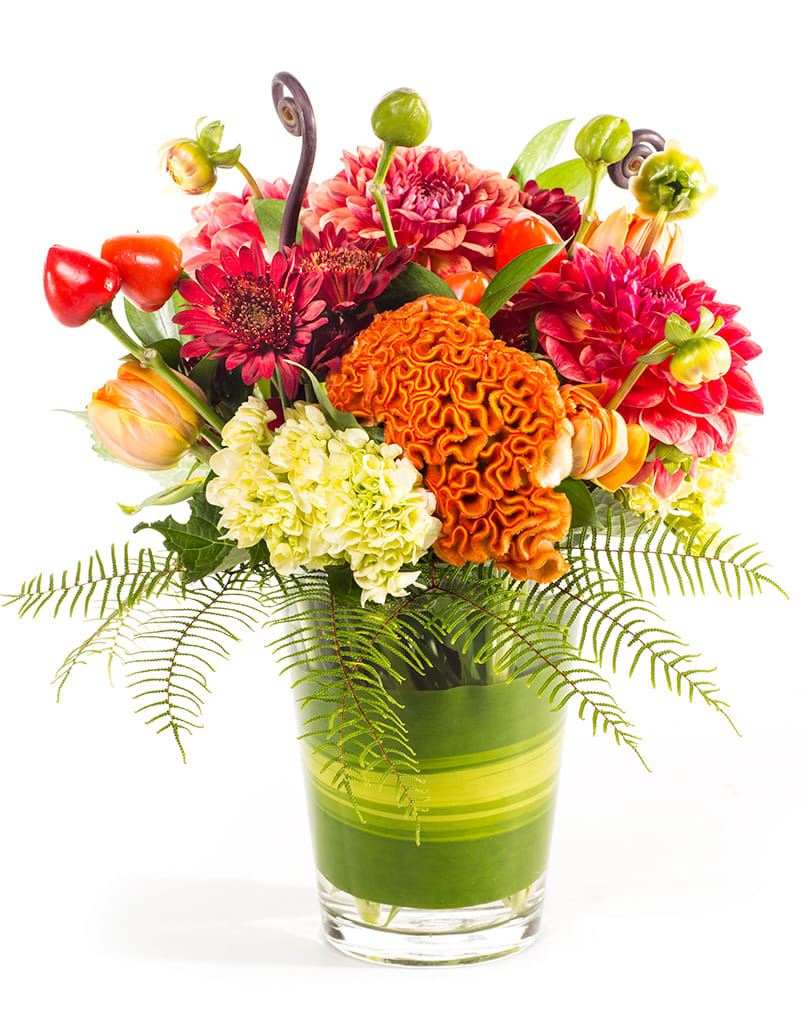 Colorful mixed bouquet in a glass vase with orange and pink blooms