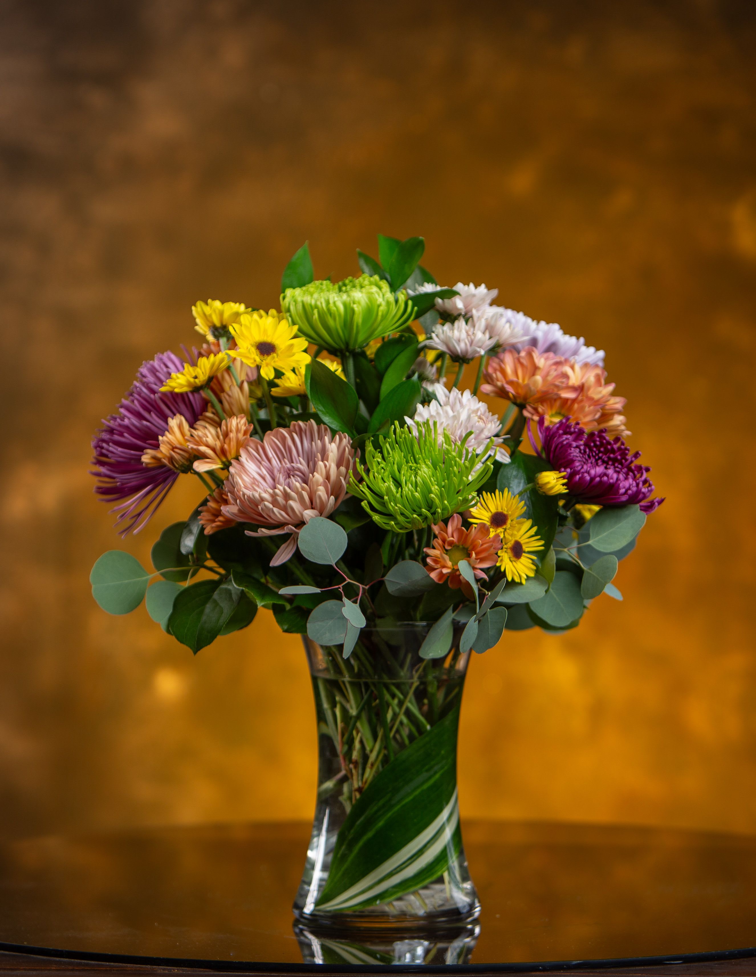 Mixed bouquet of colorful chrysanthemums in a clear glass vase