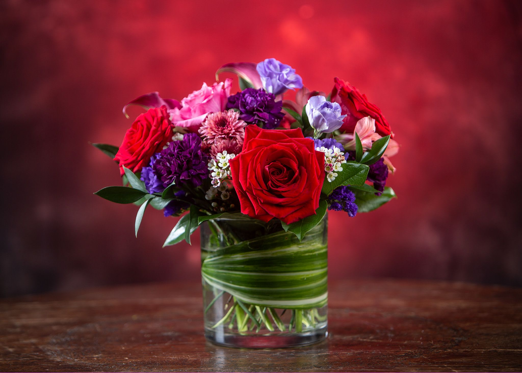 Red and purple mixed bouquet in a glass vase