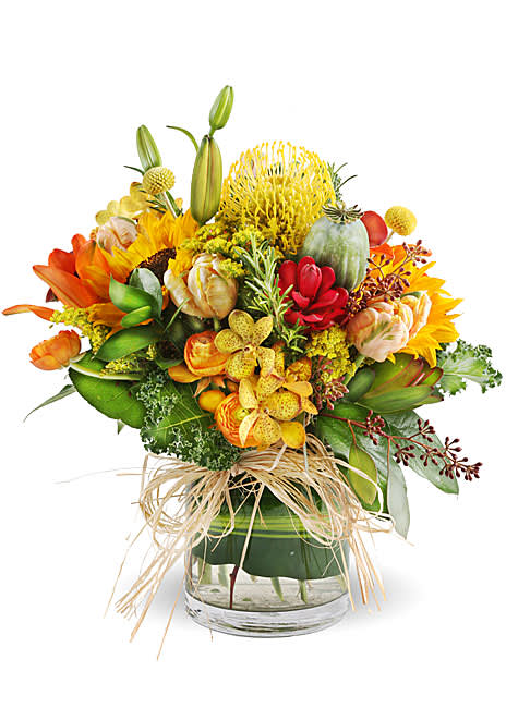 Colorful bouquet in a clear glass vase with sunflowers and lilies