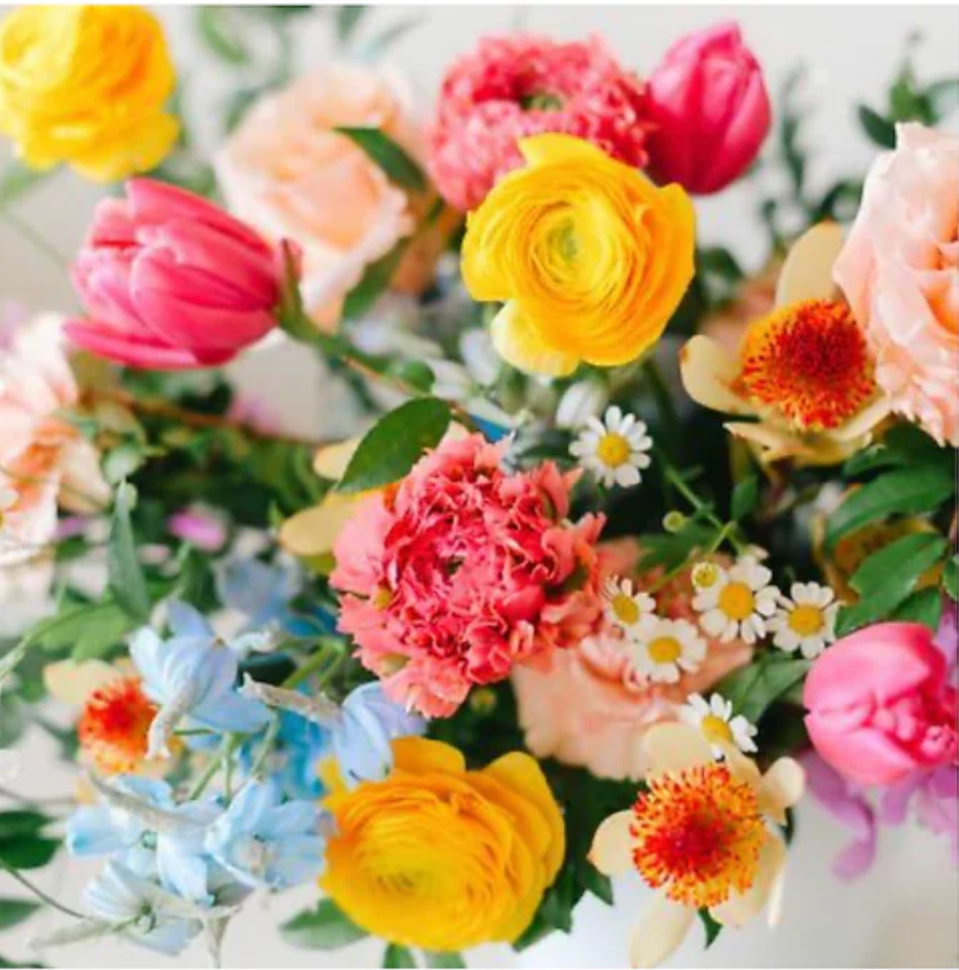 Colorful mixed bouquet with yellow, pink, peach, and blue flowers