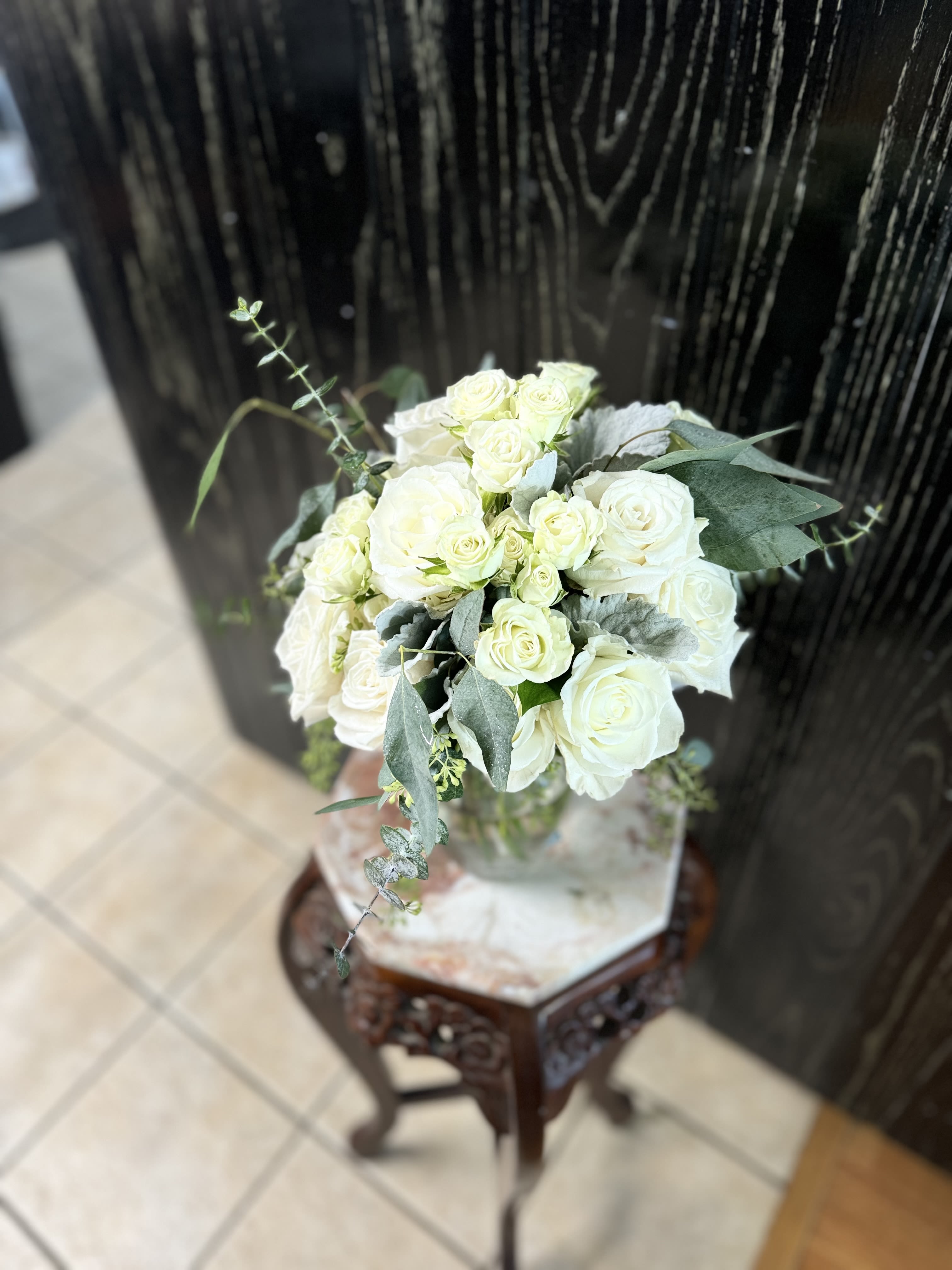 White rose bouquet with eucalyptus in a glass vase
