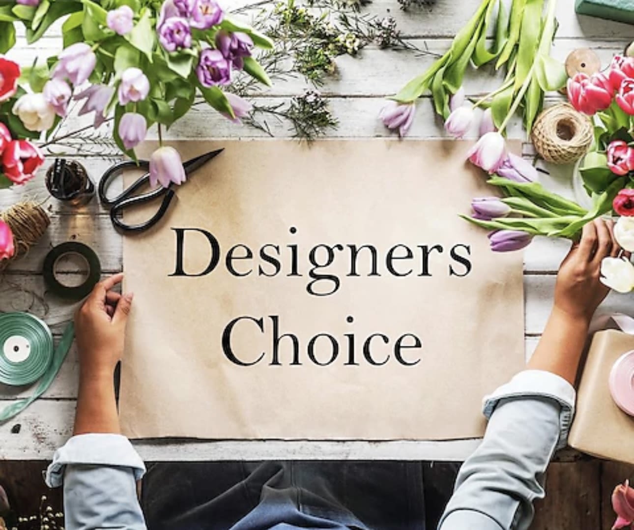 Tulips and floral supplies arranged around a sign reading Designers Choice