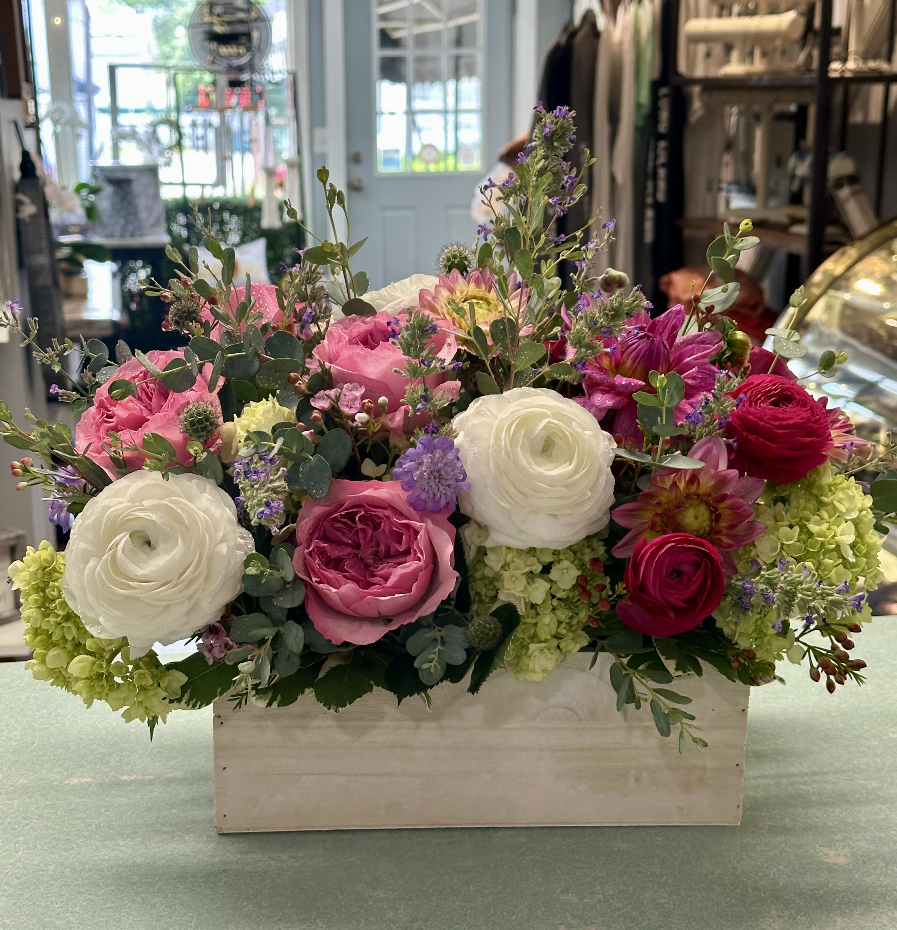 Mixed pink and white flowers arranged in a wooden box