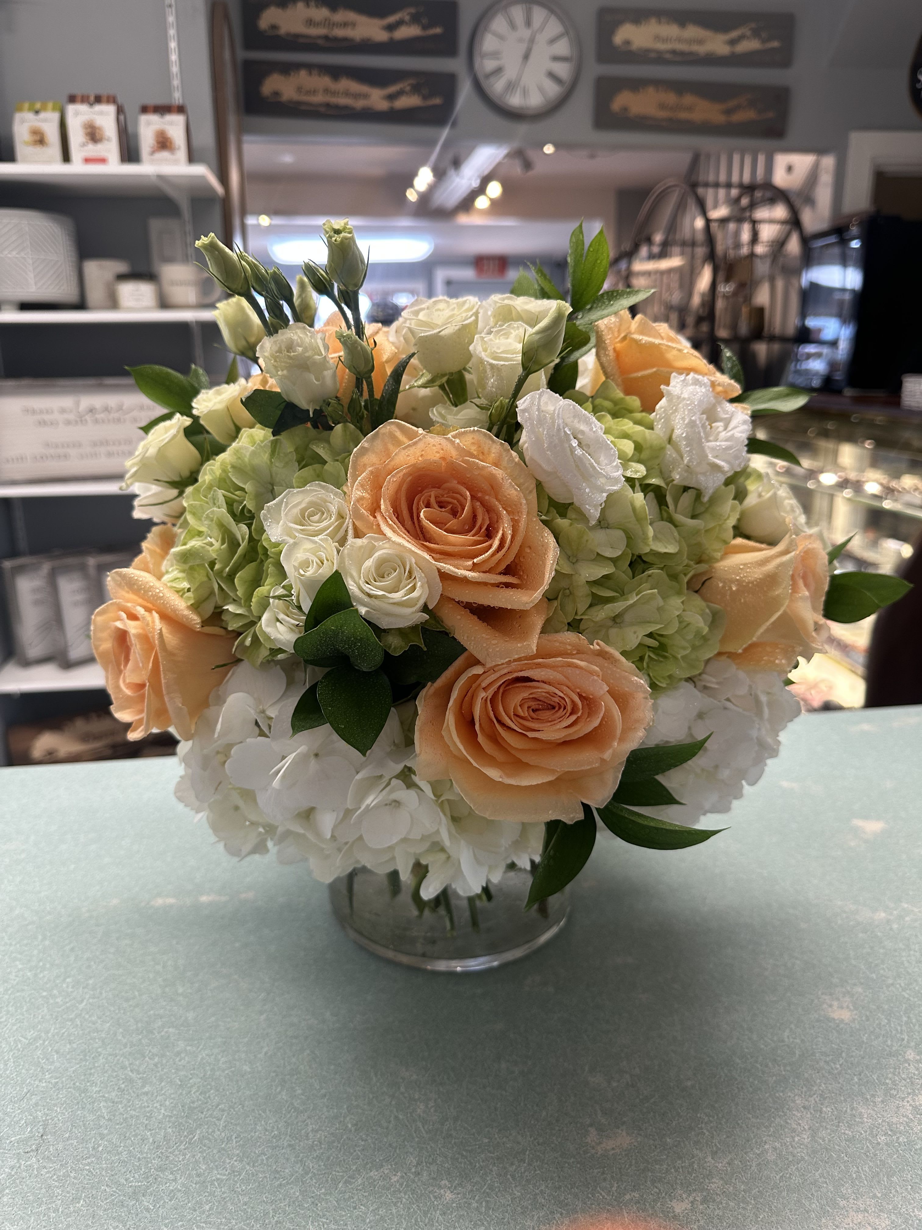 Peach and white rose bouquet with hydrangeas in a glass vase