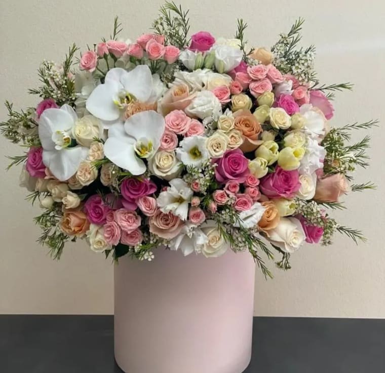 Large bouquet of pink and white roses in a pale pink vase