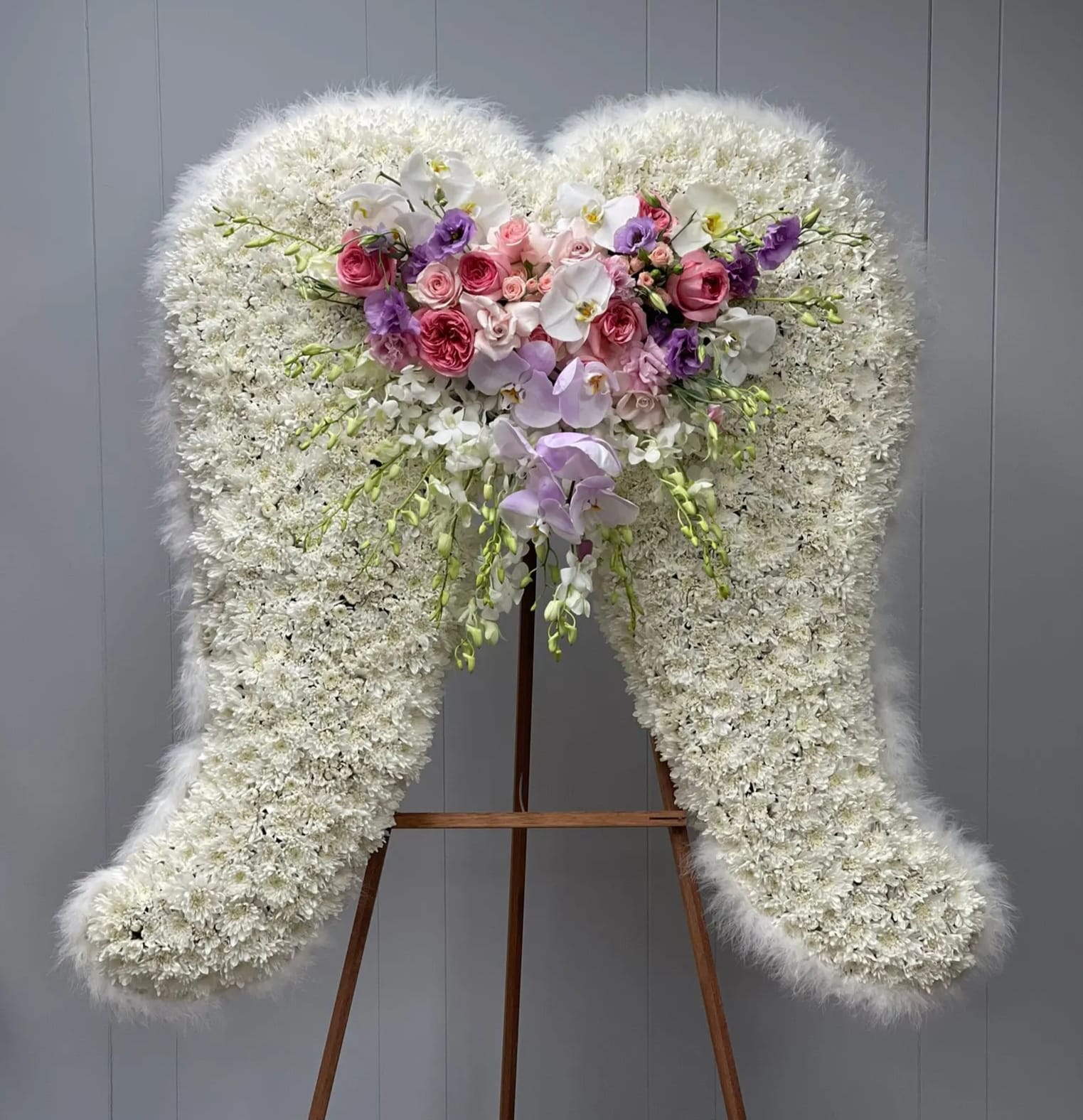 Large white floral standing spray with pink and purple roses and orchids