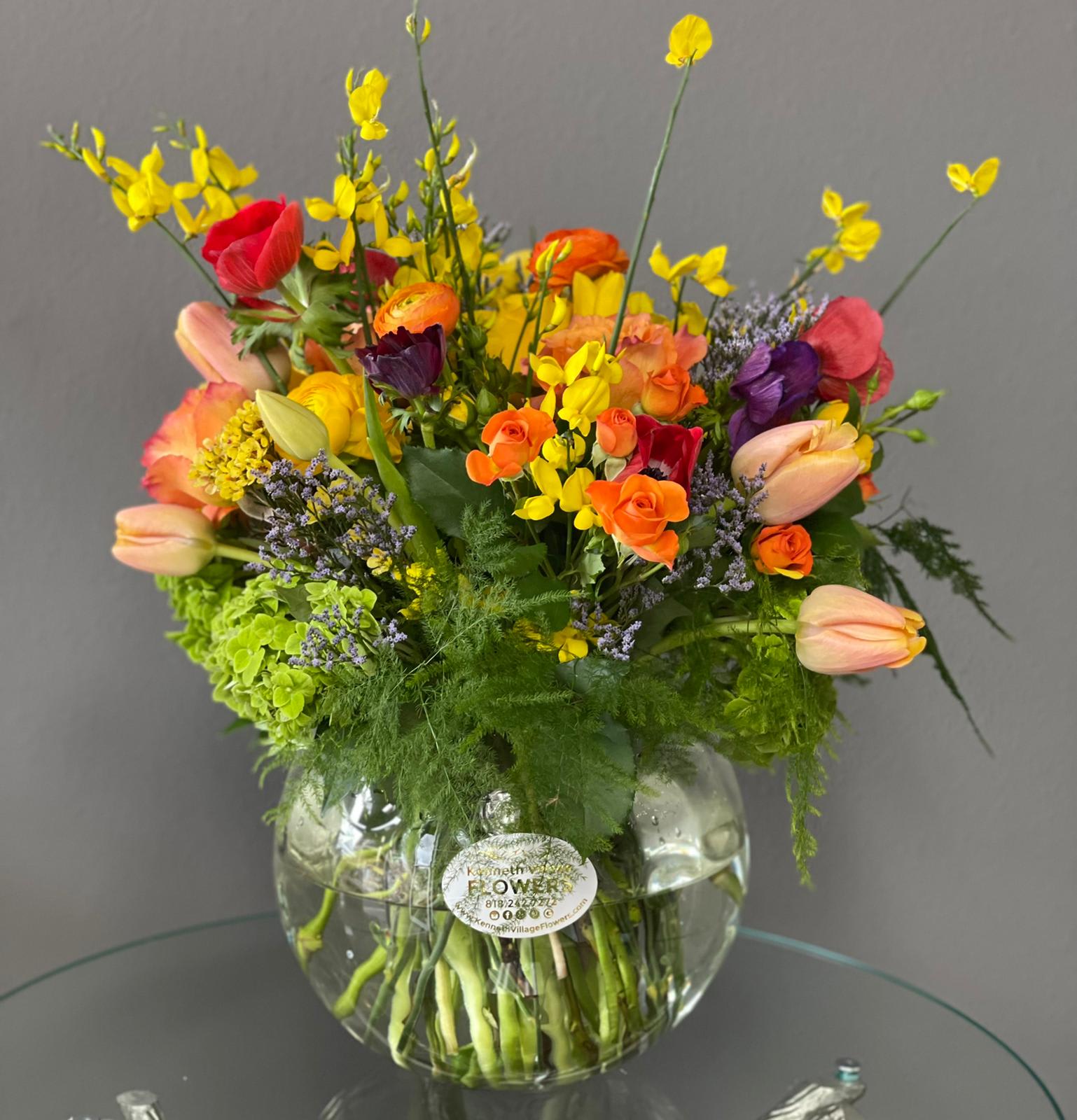 Colorful mixed bouquet in a round glass vase