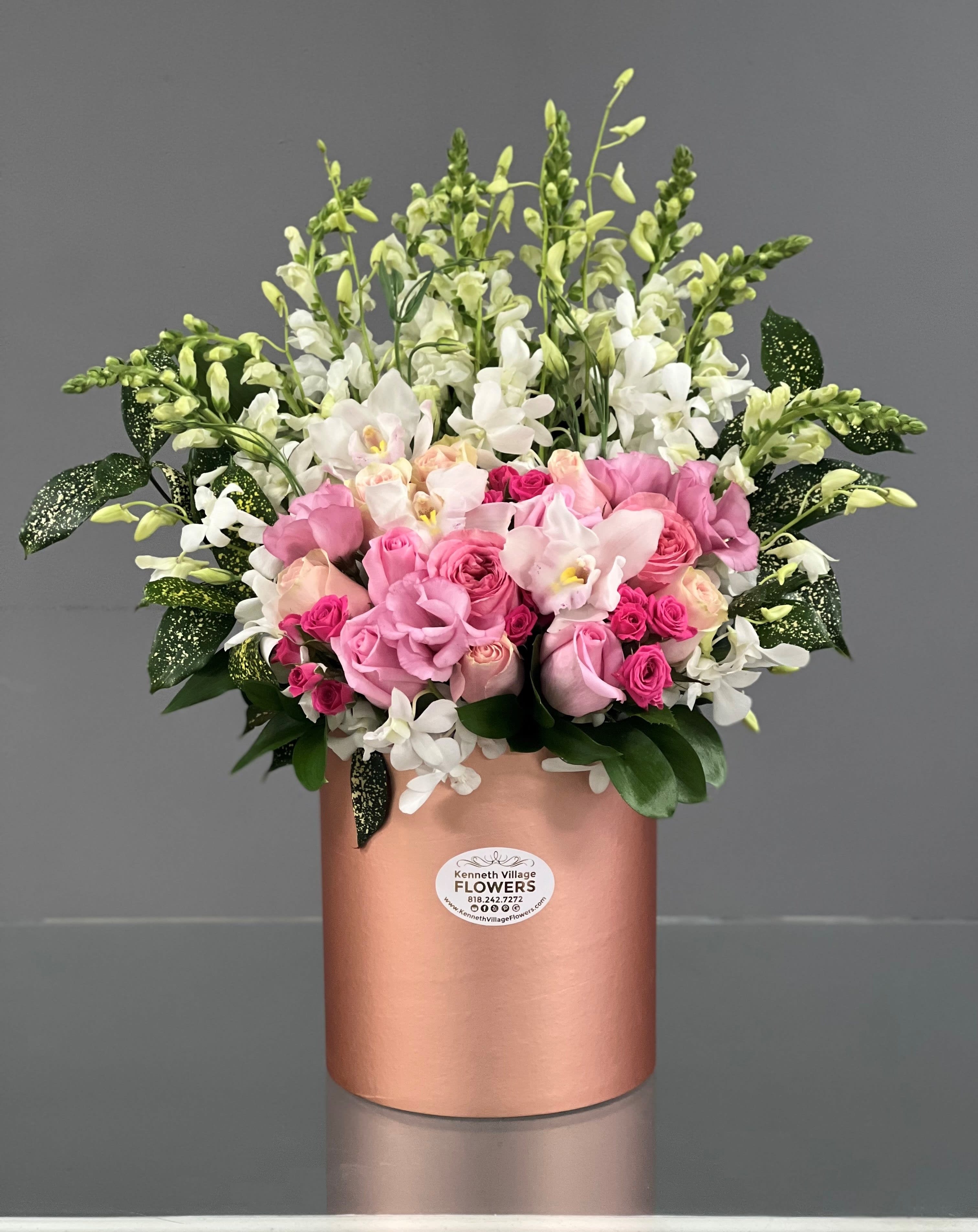 Pink and white floral arrangement in a rose-gold cylindrical box