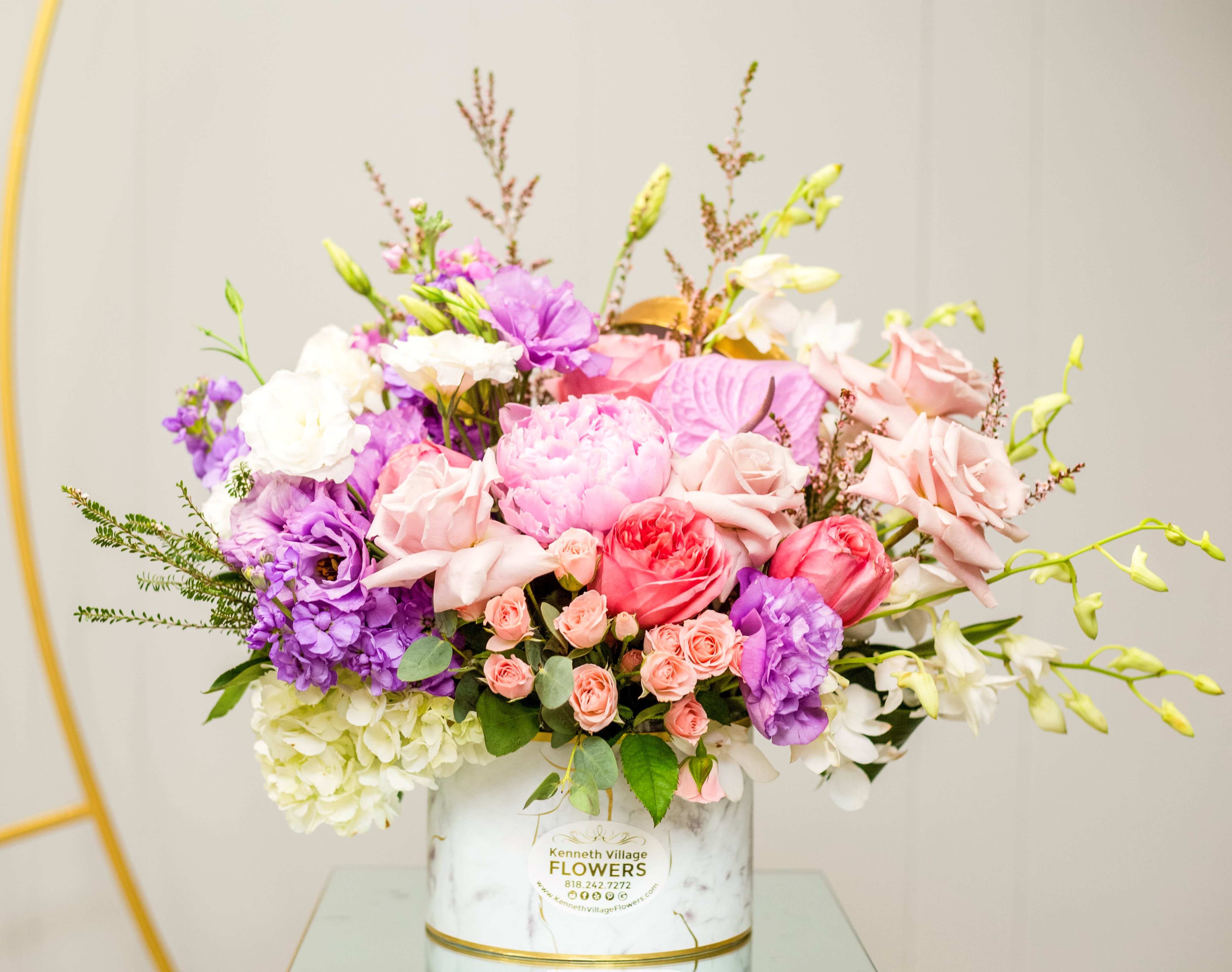 Mixed pink, purple, and white bouquet in a white vase