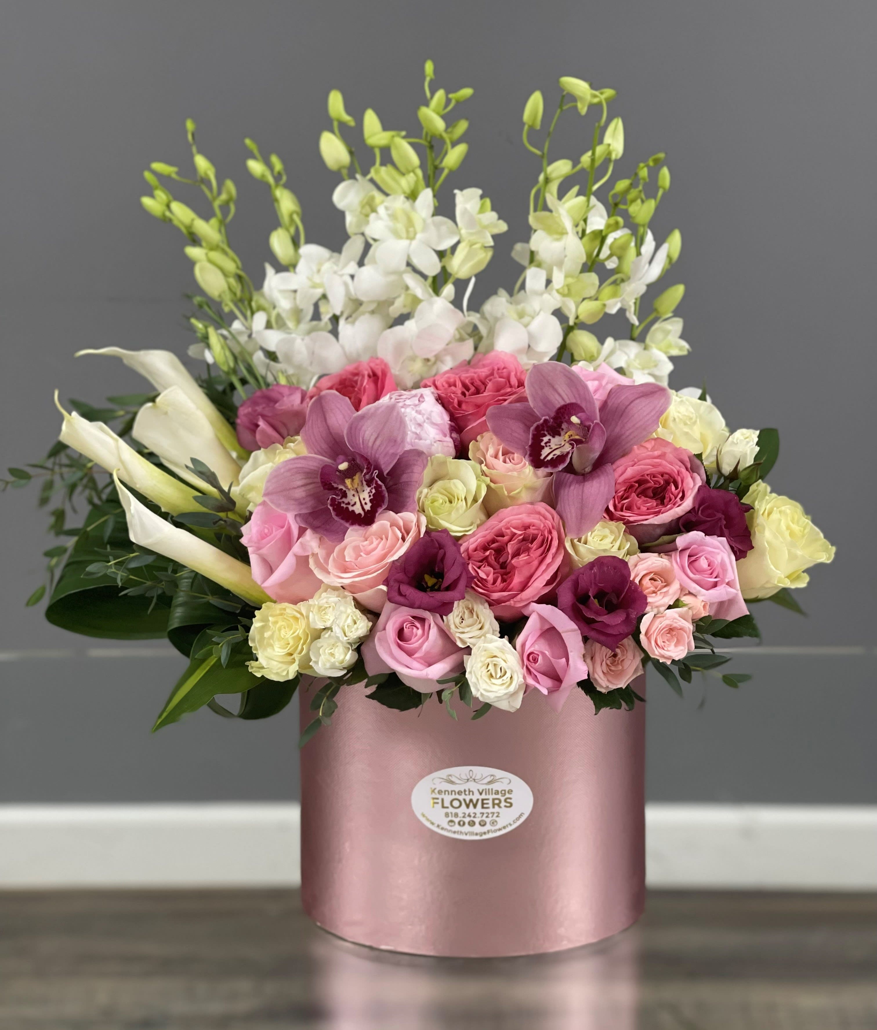 Pink and white mixed flower arrangement in a round pink box