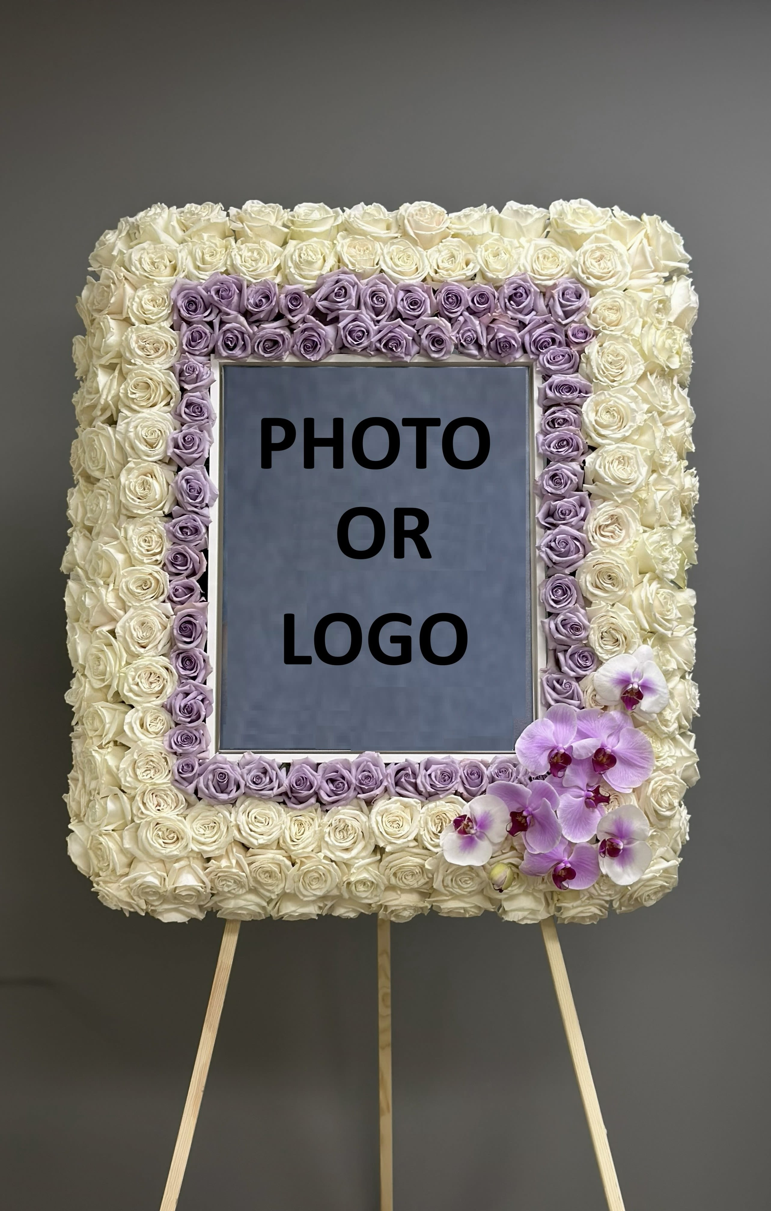 Rose-covered square easel display with a photo or logo center and orchids at the lower right