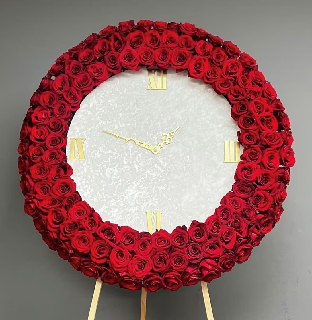 Red rose wreath arranged as a clock face on an easel